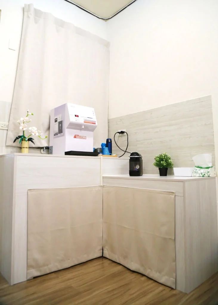 健身工作室的休息茶水區，配有純水飲水機、膠囊咖啡機與空氣清淨機